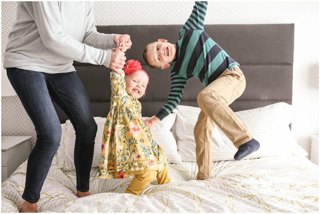 Children playing in bed during Lakeville family photo session
