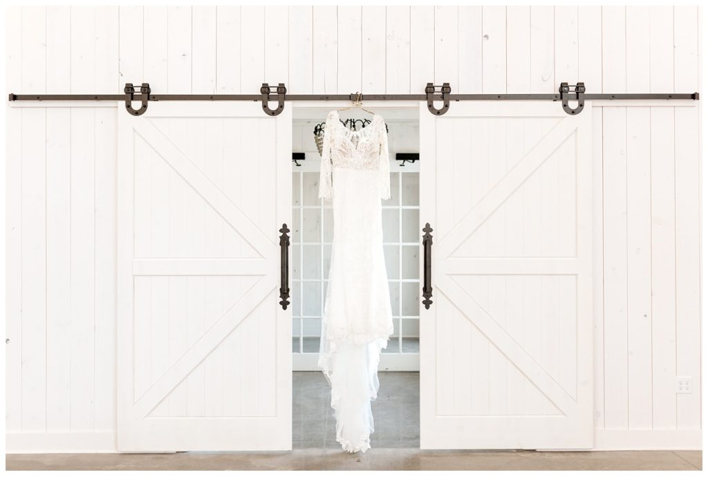 Maggie Sottero Wedding Gown hanging on White Barn Doors
