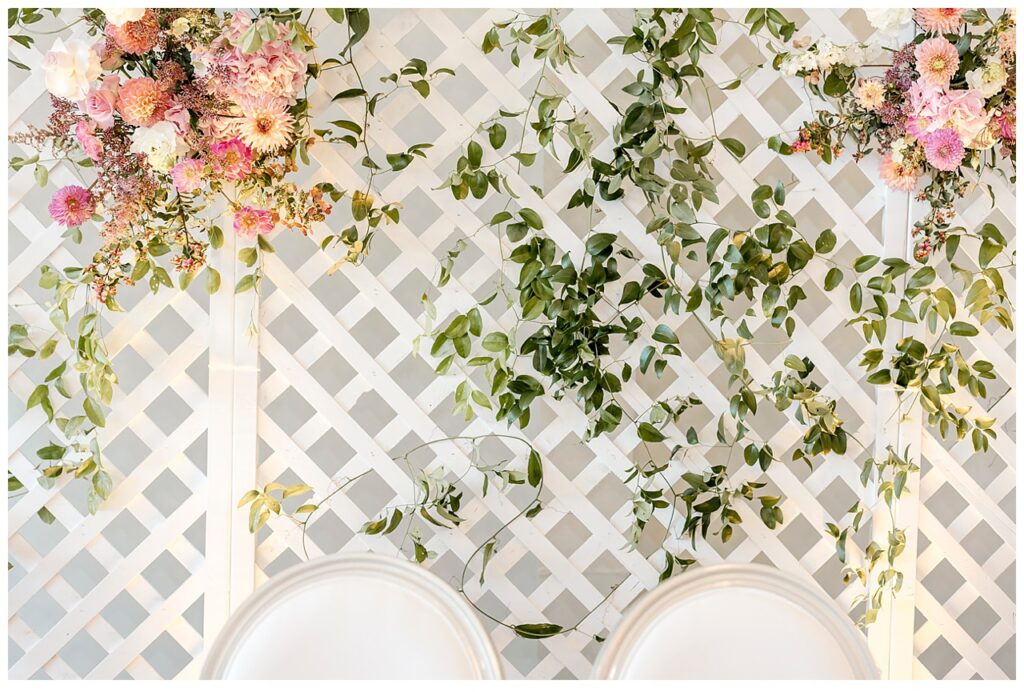 Spring flowers and vines hang from lattice work in the reception space of Bavaria Downs. 