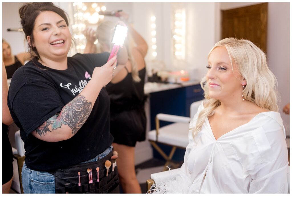 Bride and makeup artist smile before wedding ceremony at Equestria West in Chaska, Minnesota. 
