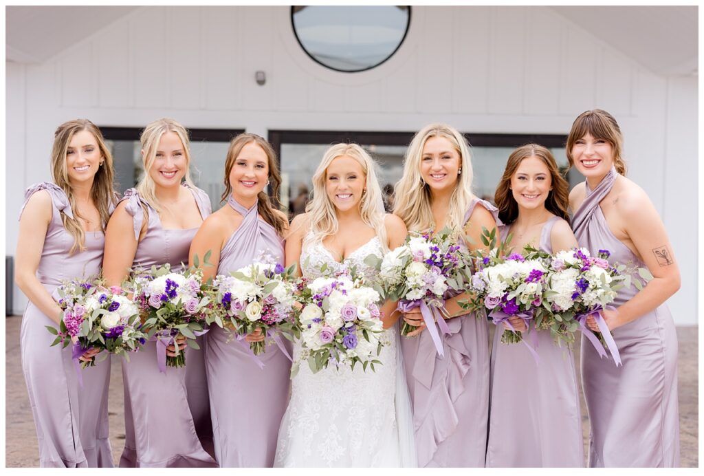 Bride and bridesmaids pose with bouquets before wedding ceremony in Chaksa, Minnesota. 