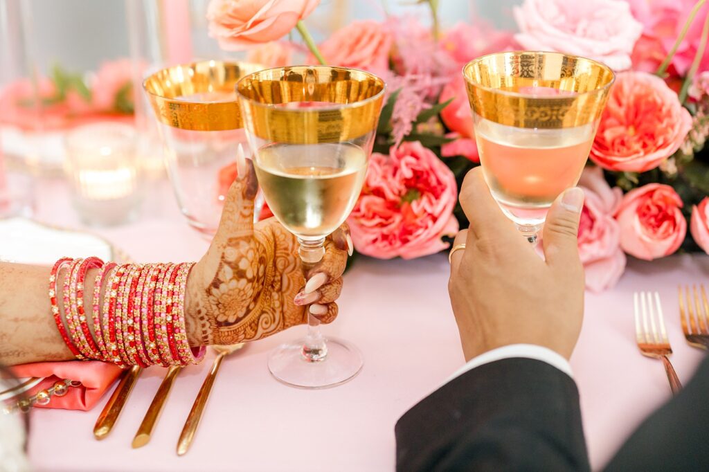 Closeup of portrait of newlyweds toasting champagne glasses during wedding reception. 